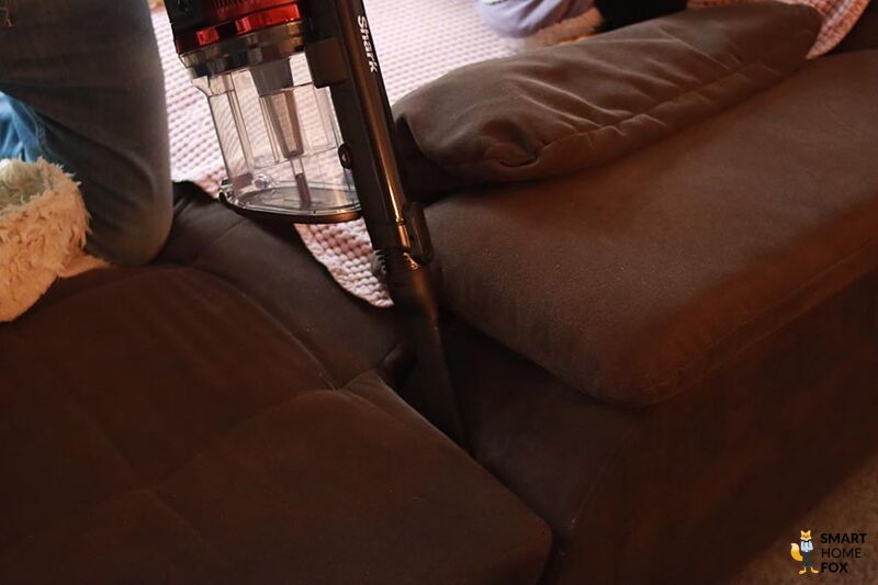 Man sieht die Reinigung von Polstermöbeln mit dem Shark Anti Hair Wrap Flexology.